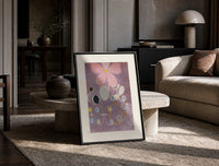Abstract flower with swirls and circles print in a black frame leaning on a travertine table in a sunlit lounge