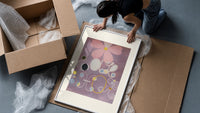 Abstract flower with swirls and circles framed print being unpacked from protective bubble wrap and a box