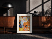 Black-framed Abstract spirals and snail shells print on a moody console with designer coffee-table books