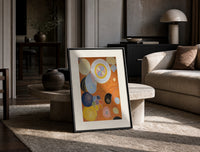 Abstract spirals and snail shells print in a black frame leaning on a travertine table in a sunlit lounge