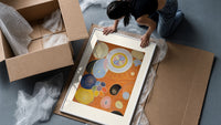 Abstract spirals and snail shells framed print being unpacked from protective bubble wrap and a box