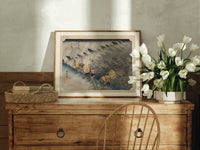 Travelers in rainstorm on hillside path print in an oak frame on a farmhouse dresser beside white tulips