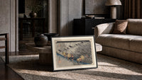 Travelers in rainstorm on hillside path print in a slim black frame leaning on a travertine coffee table