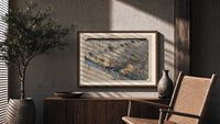 Travelers in rainstorm on hillside path print in a wood frame above a fluted sideboard beside an olive tree