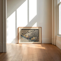 Travelers in rainstorm on hillside path print in an oak frame on a sunlit wood floor beneath tall window light