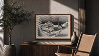 Snowy Japanese village travelers at night print in a wood frame above a fluted sideboard beside an olive tree