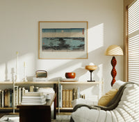 Japanese bay landscape with moon print in an oak frame above a mid-century book console with a vintage radio