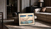 Flock of geese flying over bay print in a slim black frame leaning on a travertine coffee table