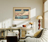 Flock of geese flying over bay print in an oak frame above a mid-century book console with a vintage radio