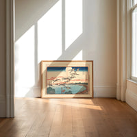 Flock of geese flying over bay print in an oak frame on a sunlit wood floor beneath tall window light