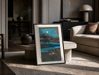 Women washing cloth by moonlit river print in a black frame leaning on a travertine table in a sunlit lounge