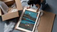 Women washing cloth by moonlit river framed print being unpacked from protective bubble wrap and a box