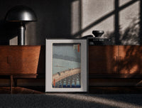Black-framed People crossing bridge in rain print on a moody console with designer coffee-table books