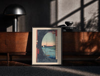 Black-framed River landscape with plum blossom branch print on a moody console with designer coffee-table books
