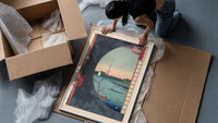 River landscape with plum blossom branch framed print being unpacked from protective bubble wrap and a box