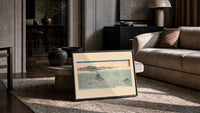Japanese whirlpools and coastal seascape print in a slim black frame leaning on a travertine coffee table
