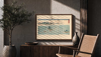 Japanese whirlpools and coastal seascape print in a wood frame above a fluted sideboard beside an olive tree