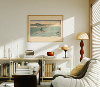 Japanese whirlpools and coastal seascape print in an oak frame above a mid-century book console with a vintage radio