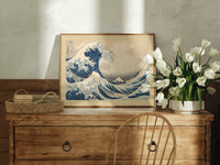 Great wave with boats and Mount Fuji print in an oak frame on a farmhouse dresser beside white tulips