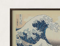 Close-up of the Great wave with boats and Mount Fuji print's dark wood frame corner and archival matte paper