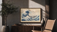 Great wave with boats and Mount Fuji print in a wood frame above a fluted sideboard beside an olive tree