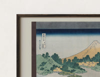 Close-up of the Mount Fuji reflected in water print's dark wood frame corner and archival matte paper