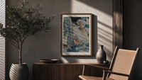 Japanese waterfall with travelers and hut poster framed above a fluted sideboard beside an olive tree