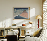 Mount Fuji with snow-capped peak print in an oak frame above a mid-century book console with a vintage radio