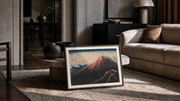 Mount Fuji with lightning storm print in a slim black frame leaning on a travertine coffee table