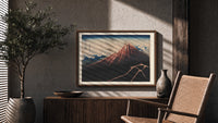 Mount Fuji with lightning storm print in a wood frame above a fluted sideboard beside an olive tree