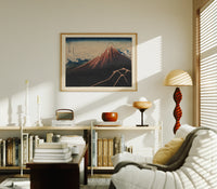 Mount Fuji with lightning storm print in an oak frame above a mid-century book console with a vintage radio