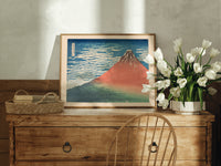 Red Mount Fuji with clouds print in an oak frame on a farmhouse dresser beside white tulips