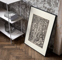 Adam and Eve in Eden poster in a black frame leaning beside a shelf in a raw-plaster loft
