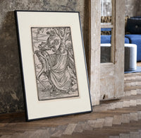 Death leading a robed figure print in a black frame leaning beside a vintage door on parquet