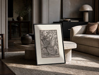 Death leading a robed figure print in a black frame leaning on a travertine table in a sunlit lounge