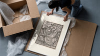 Death leading a robed figure framed print being unpacked from protective bubble wrap and a box