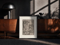 Black-framed Death fighting armored nobleman print on a moody console with designer coffee-table books