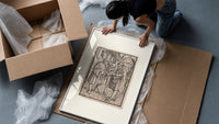 Death confronts man, Dance of Death framed print being unpacked from protective bubble wrap and a box