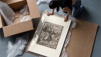 Death dancing with a man framed print being unpacked from protective bubble wrap and a box