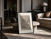 Death plowing field with farmer print in a black frame leaning on a travertine table in a sunlit lounge