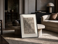 Death visits the Pope crowning emperor print in a black frame leaning on a travertine table in a sunlit lounge