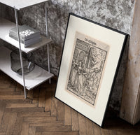 Death leading a queen away poster in a black frame leaning beside a shelf in a raw-plaster loft