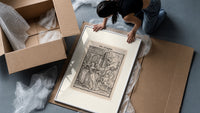 Death leading a queen away framed print being unpacked from protective bubble wrap and a box