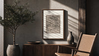 Ship in stormy sea with figures poster framed above a fluted sideboard beside an olive tree