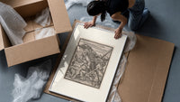 Peasant carrying load with Death skeleton framed print being unpacked from protective bubble wrap and a box