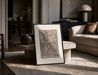 Death expelling Adam and Eve from Eden print in a black frame leaning on a travertine table in a sunlit lounge