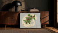 Holly Hearty Christmas Greetings print in a black frame leaning against a walnut sideboard