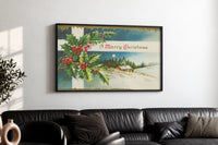 Cottage A Merry Christmas print in a black frame above a black leather sofa on a white wall