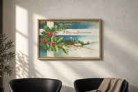 Cottage A Merry Christmas print in an oak frame on a sunlit wall above two leather armchairs