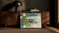 Cottage A Merry Christmas print in a black frame leaning against a walnut sideboard